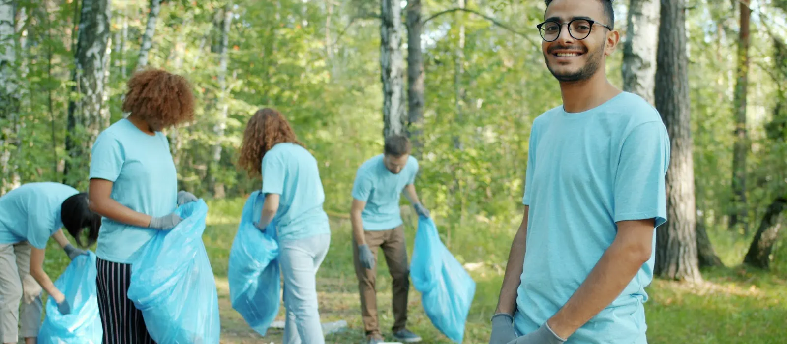 Volunteers cleaning a park with blue bags