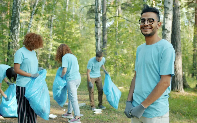 Volunteers cleaning a park with blue bags