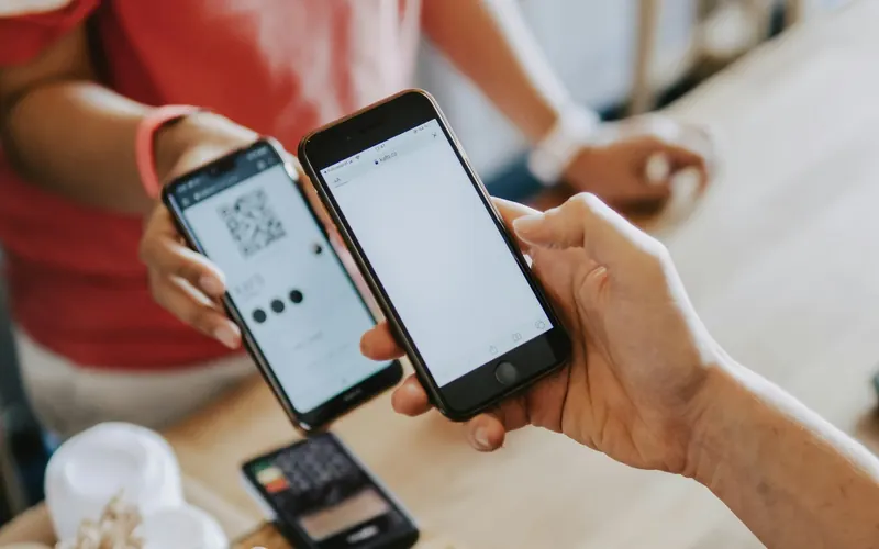 Two people's hands holding smartphones