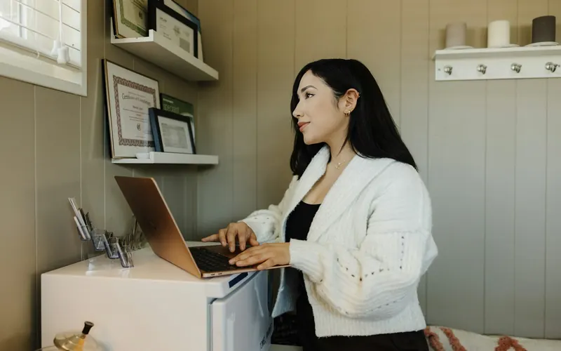 A woman working at a desk on a laptop