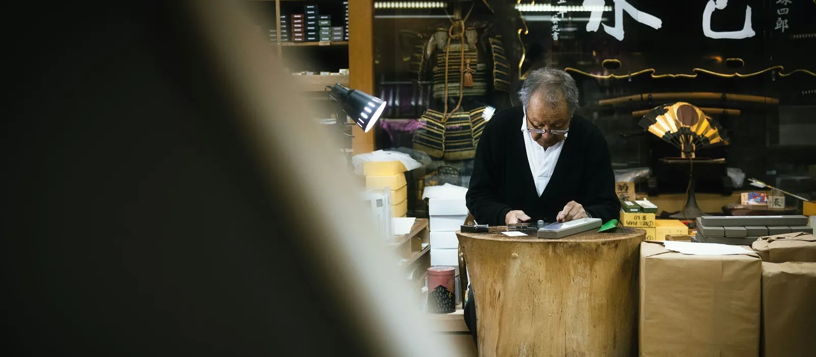A shopkeeper working at the counter of a small shop