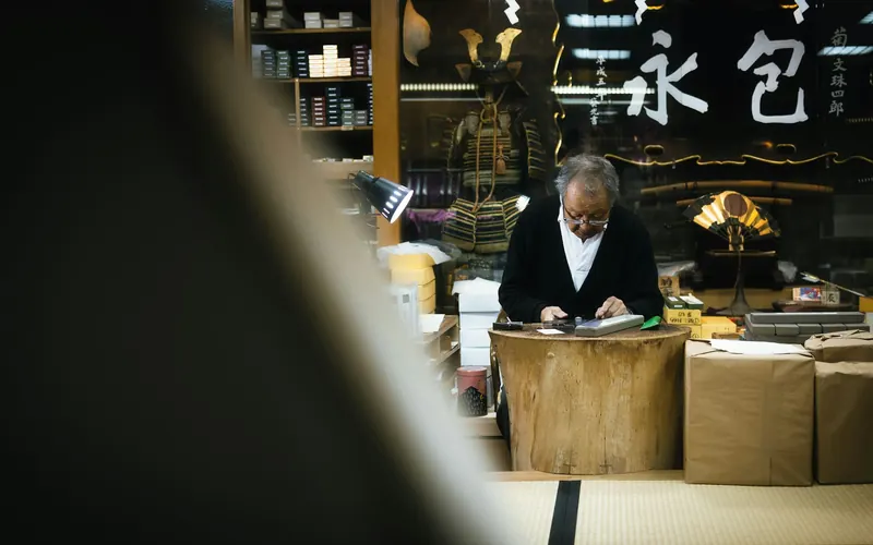 A shopkeeper working at the counter of a small shop